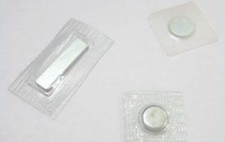 Invisible magnetic snaps with iron shell coating for focused single-sided attraction