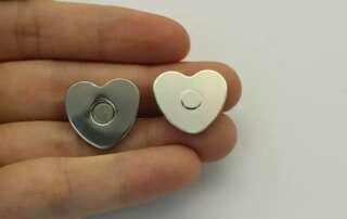 Hand Holding Silver Heart Shape Magnetic Snaps
