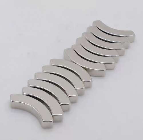 A row of arc segment neodymium magnets showing the curved profile and thickness