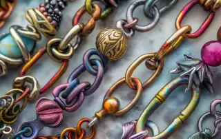A vibrant close-up view of various artistic chain clasps, including magnetic, box, lobster claw, toggle, barrel, ball, and push button clasps, showcased against a soft velvet background, highlighting their unique designs and craftsmanship in creative jewelry. Ideal for chain clasp wholesale.