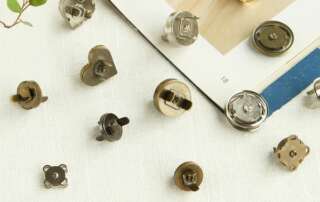 Close-up of round custom magnetic snap fastener installation process with metal prongs