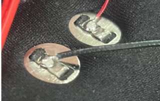 Red and black wires soldered to the rear of two snap terminals