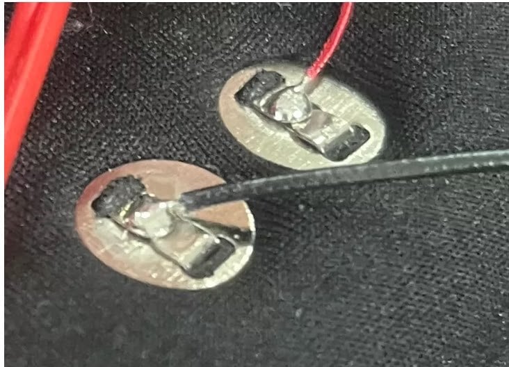 Red and black wires soldered to the rear of two snap terminals