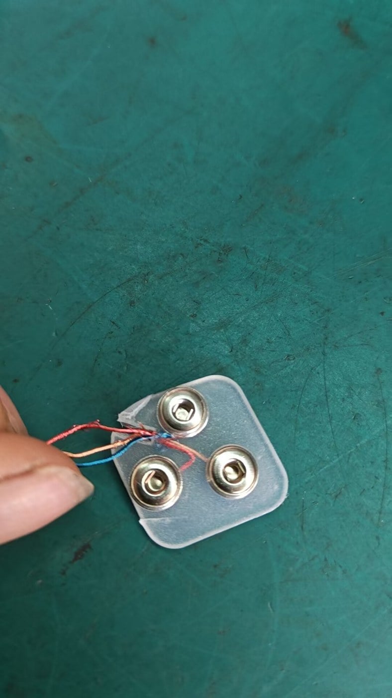 Three snap terminals and fine wires on a flexible backing