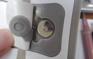 Close view of a cable-side fitting beside a round electrode stud